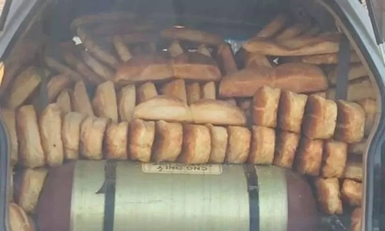 Մեքենայի կեղտոտ բեռնախցիկում, գազի բալոնի վրա շարված հաց են տեղափոխում